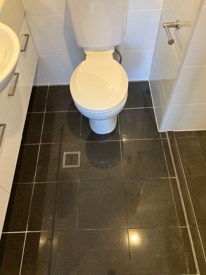 Bathroom wall tiles before regrouting, with discoloured and deteriorating grout joints
